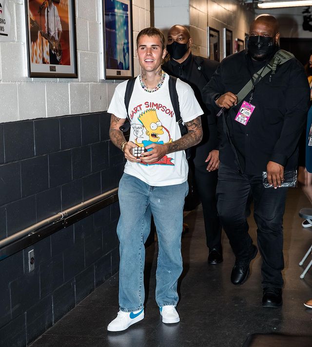 Justin Bieber mismatched sleeves tattoo in white t-shirt with bart simpson printed on it